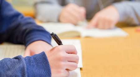 Two middle school students at a table doing school work 